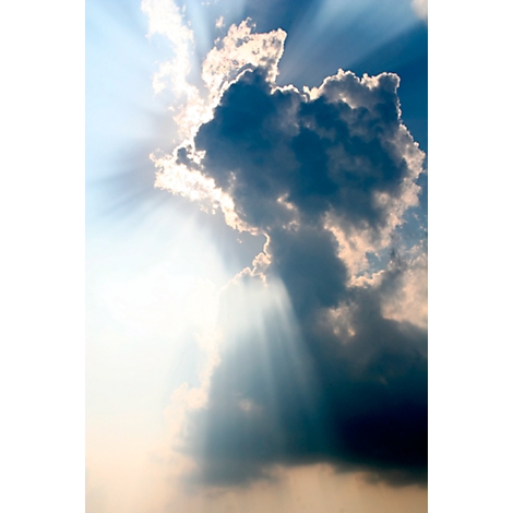 Sunbeams break through dark clouds. Bright light and shadow create a dramatic effect.