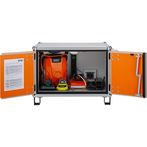 Offener silberner Koffer mit orangefarbenen Türen, gefüllt mit Elektronik. Auf der Innenseite der Tür befindet sich Text. Detailaufnahme.