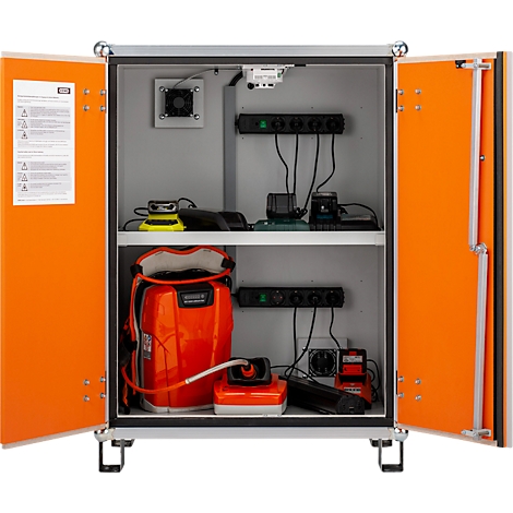 Offener Schrank mit technischer Ausrüstung: Akkus, Stromverteiler, Lüfter und orangefarbenes Equipment.