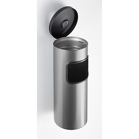 Poubelle cylindrique argentée avec couvercle noir ouvert. Rectangle noir avec couture sur le côté.