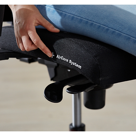 Une personne pointe le siège d'une chaise de bureau. La chaise porte l'inscription "AirCare System".