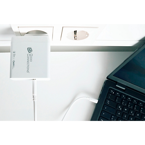 Chargeur d'ordinateur portable blanc avec câble connecté à une prise et à un ordinateur portable. Le chargeur indique 'Good Connections'.