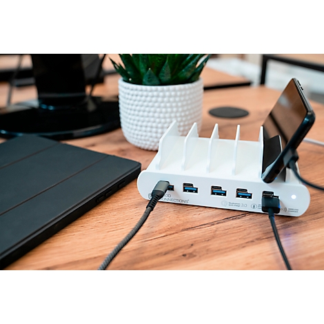 Chargeur blanc avec plusieurs ports USB, un smartphone et une tablette sont en charge.