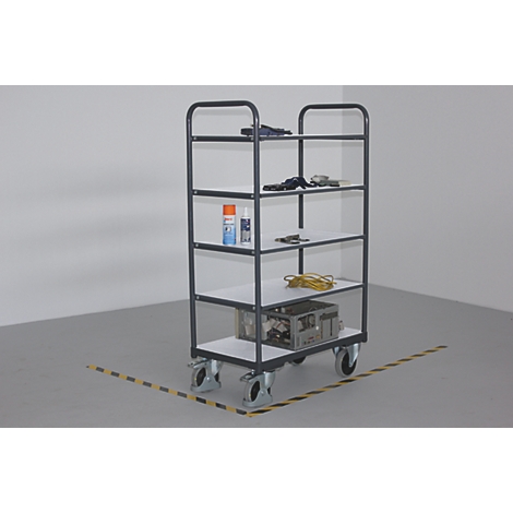 Un chariot de service gris avec des outils et de l'équipement se trouve dans une pièce.
