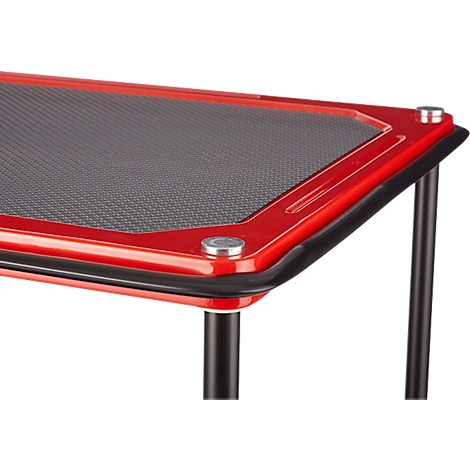 Gros plan d'une table rouge. La table a des pieds noirs, un plateau gris et des vis argentées.