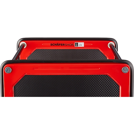 Vue de dessus d'un marchepied rouge avec des marches noires texturées. Le texte "SCHÄFERSHOP" est visible.