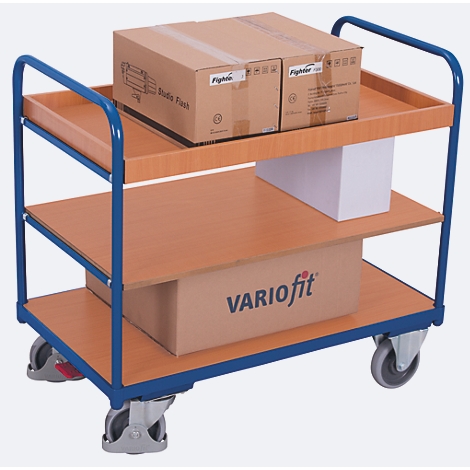 Chariot de service bleu et marron à trois niveaux. Deux boîtes en haut, un colis blanc en dessous, une boîte avec "VARIOfit" en dessous.