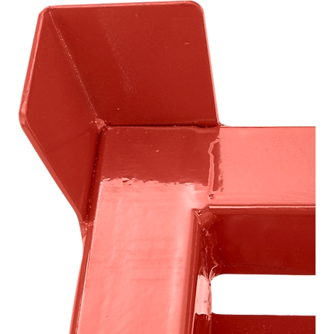 Gros plan d'une construction métallique rouge soudée avec un support incliné.