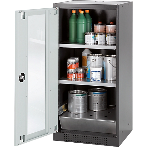 Open cabinet with various containers, paints, and liquids. Cans, bottles, and paint buckets are visible on the shelves.