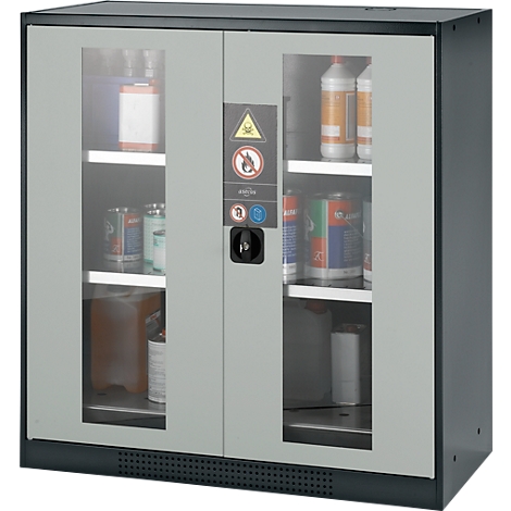 Grey safety cabinet with glass windows, filled with chemicals. Hazard symbols and black handle on the door.