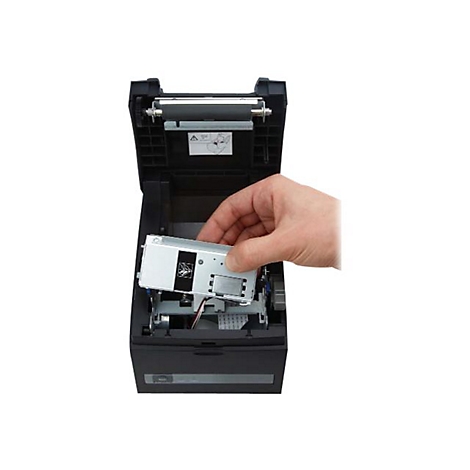 Eine Hand hält ein silbernes Bauteil in einem geöffneten schwarzen Drucker. Details sind gut sichtbar.