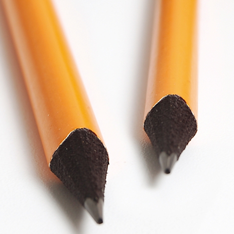 Close-up of two pencil tips lying at a light angle on a white background. The tip is made of black graphite.