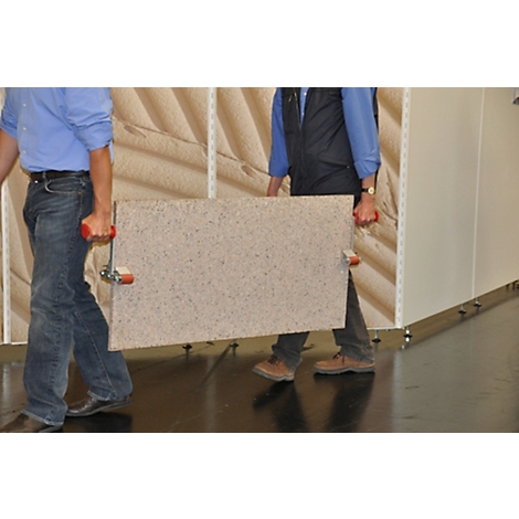 Two men are carrying a large, rectangular panel through a room.
