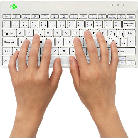Mains tapant sur un clavier blanc avec une disposition de clavier français.