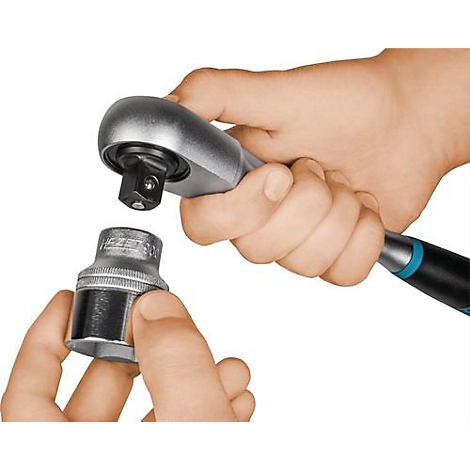 Une main tient un cliquet, l'autre une douille. Les deux outils sont argentés et noirs.