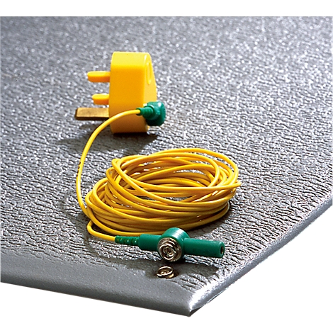 Grey ESD mat with yellow cable, plug and green connector. The mat lies on a smooth surface.
