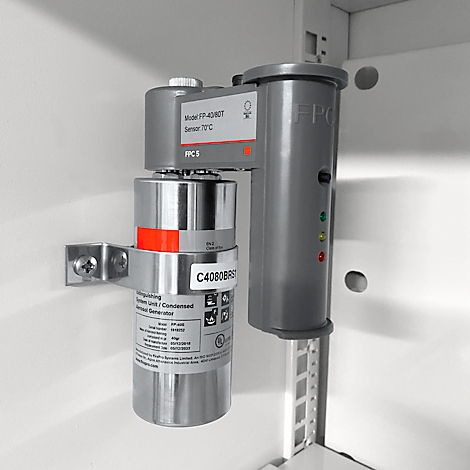 Capteur de protection incendie gris avec des LED rouges et vertes. Le capteur est monté sur un mur blanc à l'intérieur d'une armoire.