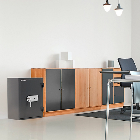 Un coffre-fort est dans un bureau. On peut voir des armoires et un bureau en arrière-plan.