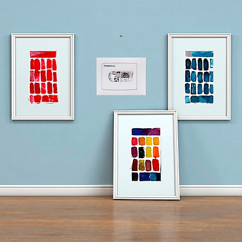Quatre œuvres encadrées sont accrochées à un mur bleu clair. Trois sont des compositions abstraites de champs de couleurs. La quatrième montre une esquisse de magnétophone à cassettes.