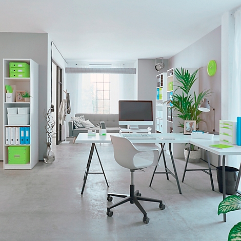 Ein helles Büro mit Schreibtisch, Stuhl und Computer. Im Hintergrund eine Couch.