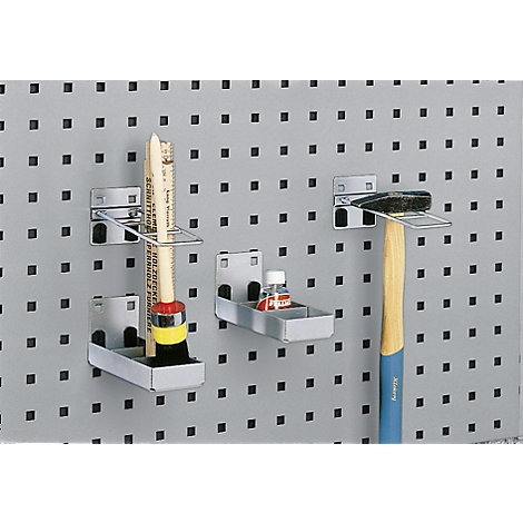 Pegboard with tools: paint brush, bottle, and a hammer in metal holders.