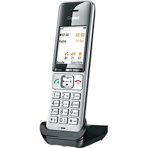 Téléphone sans fil noir et argenté sur socle de chargement. L'écran affiche l'heure, la date et les éléments du menu.