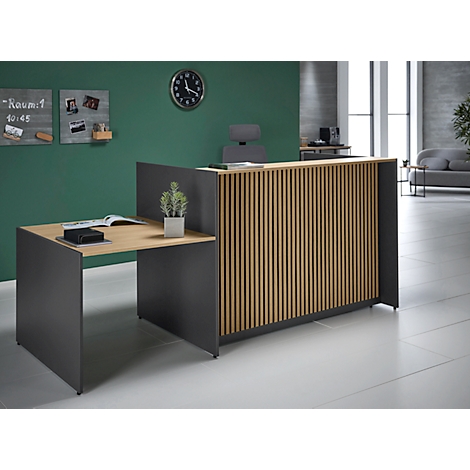 Réception avec lattes en bois, mur vert derrière, horloge, notes. Bureau, plante, livre ouvert.