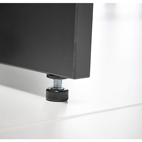 Gros plan : pied en métal noir avec pied de réglage. La base repose sur une surface blanche.