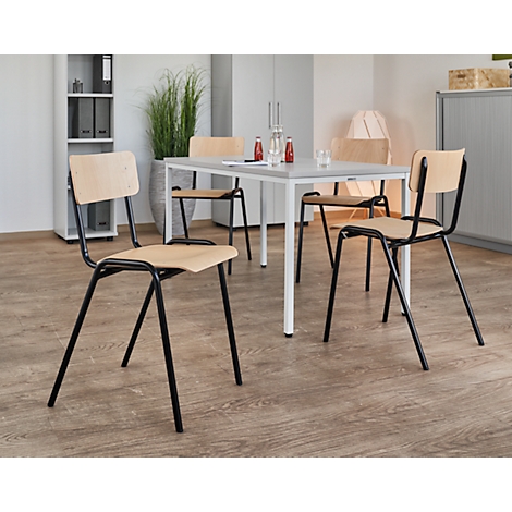 A light wood table with four chairs. Black metal frames, light-colored seats. Red and glass bottles are on the table.