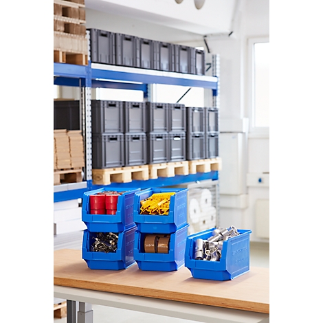 Contenedores de plástico azul llenos de varios artículos, frente a un estante de almacén.