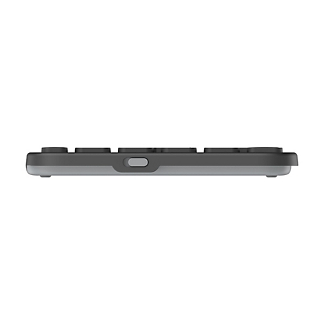 Seitenansicht einer flachen, dunkelgrauen Tastatur mit einem mittigen silbernen Anschluss auf weißem Hintergrund.