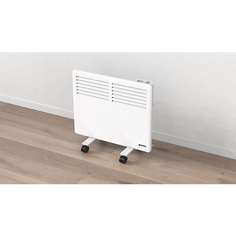 Witte radiator met wielen voor een witte muur. Lamellen aan de bovenkant.