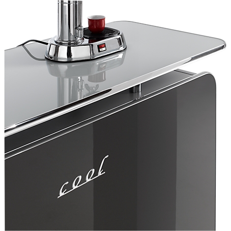 Close-up van een zwarte bar met een glanzend oppervlak, waarop een koffiemachine staat. Opschrift "cool" op de zijkant.