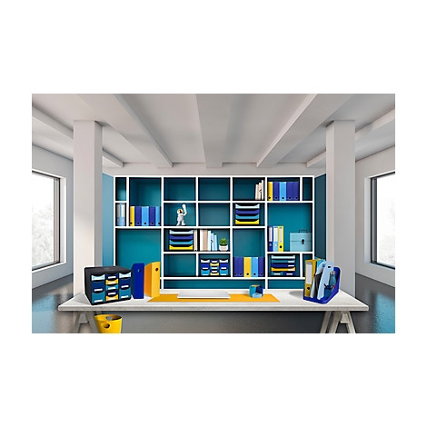 Un bureau avec des fournitures de bureau devant une étagère. Classeurs, porte-stylos et plateaux de différentes couleurs.