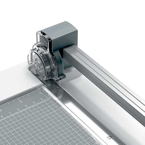 Gros plan d'une coupe-papier : protection transparente, rail argenté avec marquages.
