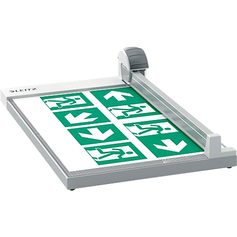 Une massicot grise coupant une feuille avec des panneaux de sortie verts.