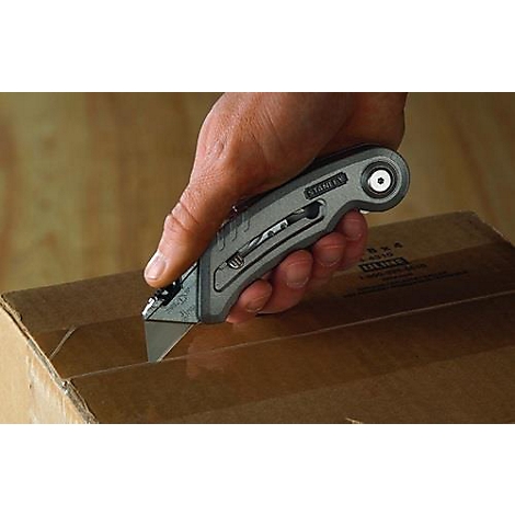 Un homme coupe un carton avec un cutter Stanley.