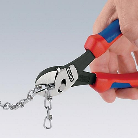 Gros plan d'une pince coupant une chaîne. La pince a des poignées rouges et bleues avec une tête noire. Chaîne métallique.