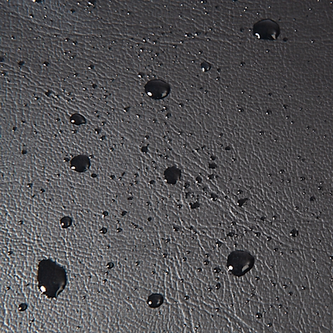 Surface noire, aspect cuir, avec des gouttelettes d'eau.