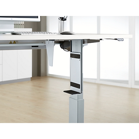 Close-up of a height-adjustable desk. The detail shows the silver frame, the black controls and the attachment.