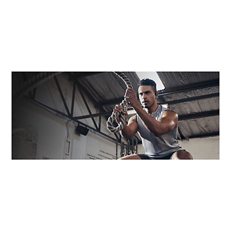 Ein muskulÃ¶ser Mann trainiert mit einem Seil in einem Fitnessstudio. Er zieht das Seil, konzentriert sich und trainiert.
