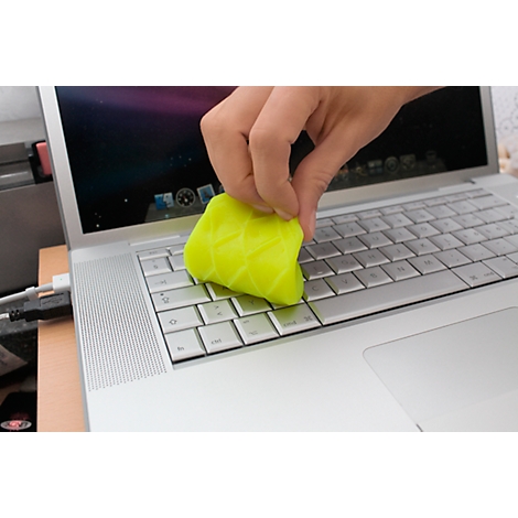 Eine Hand reinigt die Tastatur eines Laptops mit einem gelben Reinigungsgel.