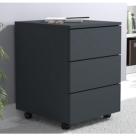 Dark gray rolling cabinet with three drawers and wheels. Glasses and a book are on top.