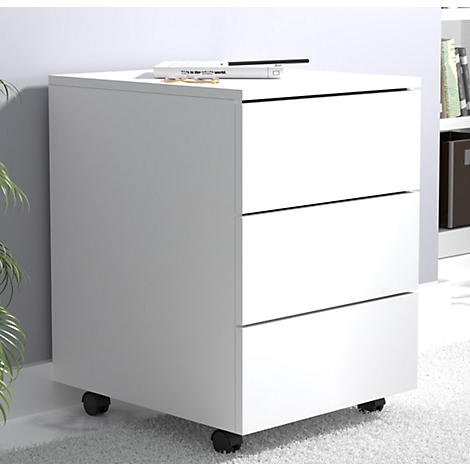 White rolling cabinet with three drawers, a book and a pen are on top. Black rollers.