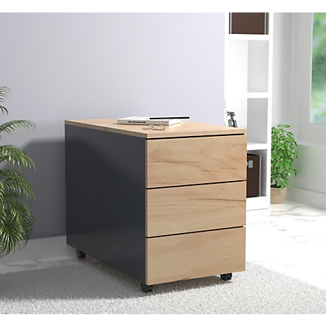 A gray rolling cabinet with three wooden drawers, a book and a pen are on top.