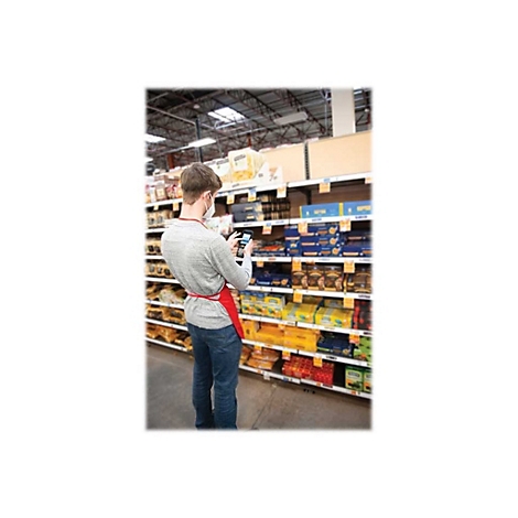 Ein Mann mit Mundschutz scannt im Supermarkt Waren. Er trÃ¤gt eine rote SchÃ¼rze.