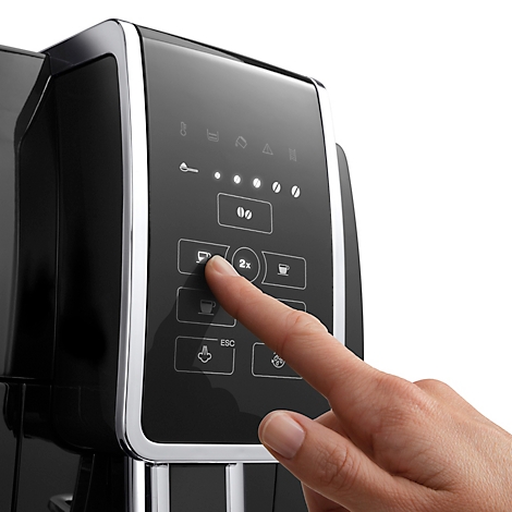 Nahaufnahme einer schwarzen Kaffeemaschine, ein Finger drückt eine Taste am Bedienfeld.