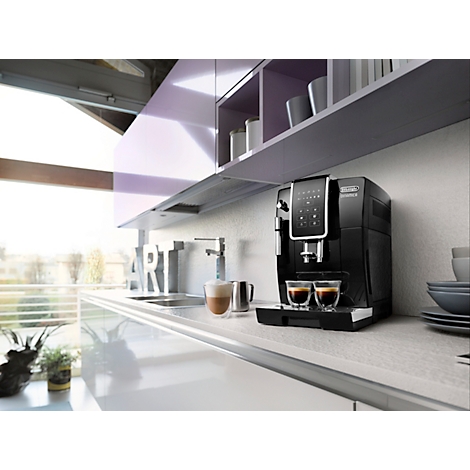 Schwarze Kaffeemaschine in Küche, zwei Espressi in Gläsern. Graue Arbeitsplatte und Schränke, Fensterblick.