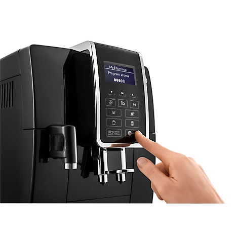 Eine schwarze Espressomaschine wird mit dem Finger bedient, ein Touchscreen zeigt Menüoptionen.