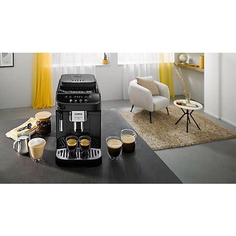Schwarze Kaffeemaschine mit Kaffeetassen und einer stilvollen Wohnzimmereinrichtung im Hintergrund.